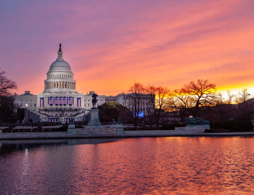 The sun is rising over the United States Capitol Building; this picture was taken in January 2013.